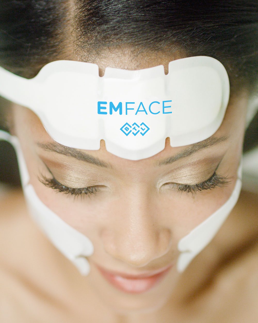 A beautiful woman wears the EMface device to lift and firm her face at Optimum Human in Albuquerque, NM.