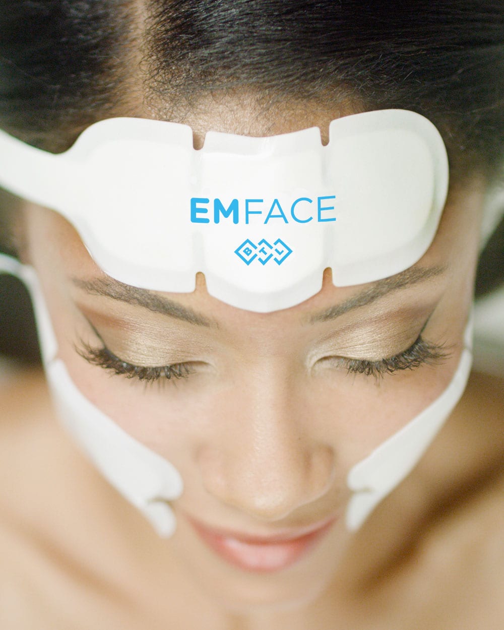 A Beautiful Woman Wears The Emface Device To Lift And Firm Her Face At Optimum Human In Albuquerque, Nm.